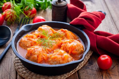 Ahşap bir masa üzerinde dökme demir tava domates sosu pirinç ile Köfte, yatay