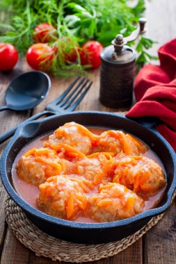 Domates soslu pilavlı köfte ve siyah dökme demir tavada sebzeler, seçici odak