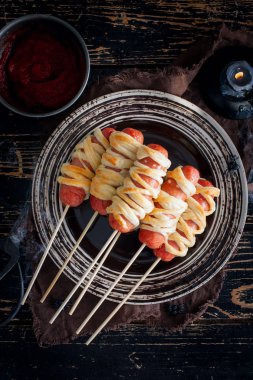 Cadılar Bayramı partisi için ahşap bir masada mumya hamuru ile Sosis, üst görünümü, seçici odak