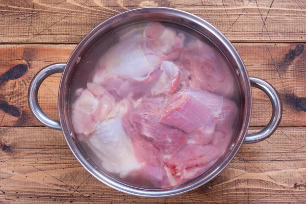 Step-by-step cooking of homemade turkey jelly, step 1 - boiling meat, top view, selective focus