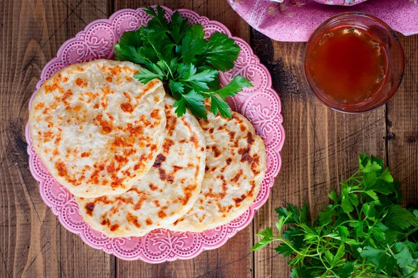 Cheese fried tortillas on a wooden table with fresh herbs, horizontal