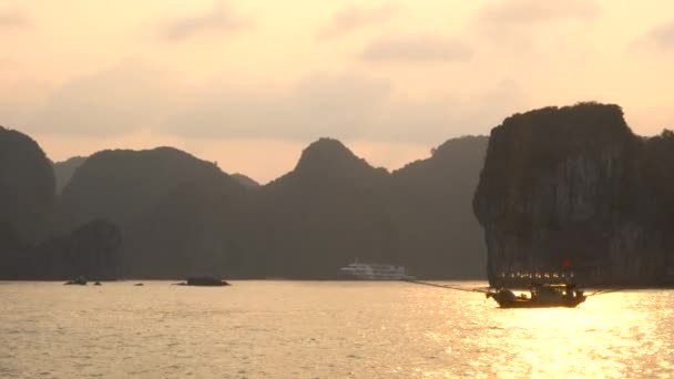 ユネスコの世界遺産であるハロン湾のサイト猫 国立公園 ベトナムの石灰岩の島々 を夕暮れ時のセーリング伝統的な漁船 — ストック動画