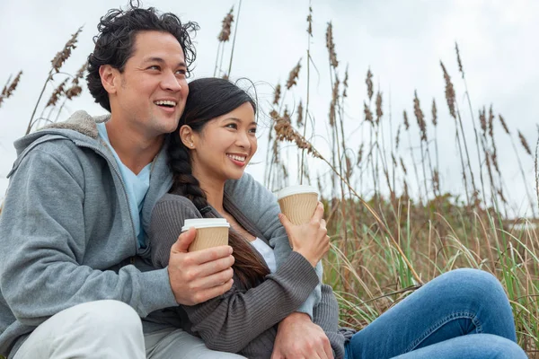 年轻的亚洲华人男人和女人 男孩女孩 一对完美的牙齿坐在海滩上喝外卖杯茶或咖啡 — 图库照片