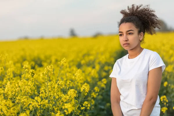 美しい混血アフリカ系アメリカ人の女の子 代の若い女性悲しい落ち込んでいるまたは黄色の花のフィールドにパスの終わりに思慮深い — ストック写真