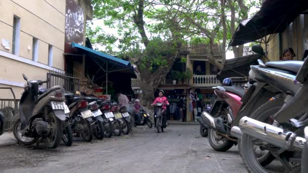 ベトナムホイアンの路上で地元の人々の乗馬と駐車スクーター6 エイプリル社2018年6月 ベトナムのホイアンの昼間の通りで人々が乗馬や駐車スクーター — ストック動画