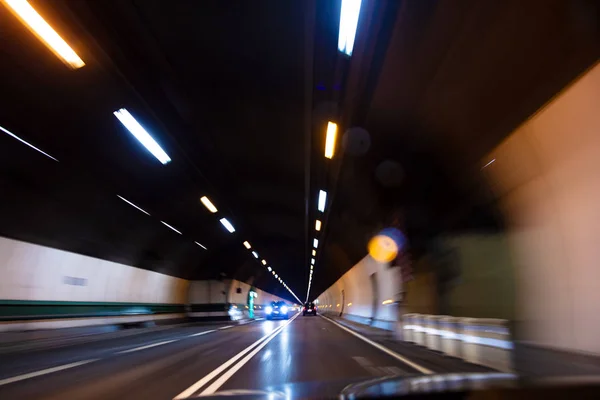 运动模糊驾驶汽车的速度通过公路隧道在夜间 — 图库照片