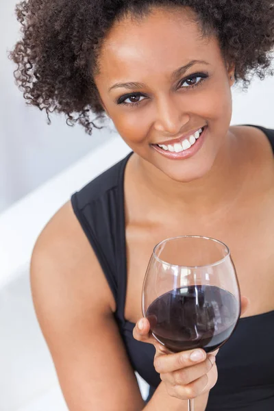 美しい幸せな混血アフリカ系アメリカ人の少女や若い女性の黒ドレスを着て 赤ワインを家で飲む — ストック写真