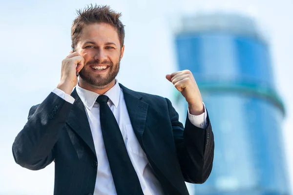 成功するビジネス人 現代の都市で高層オフィスビルの前で祝う彼のモバイル携帯電話で話す男性のエグゼクティブ ビジネスマン — ストック写真