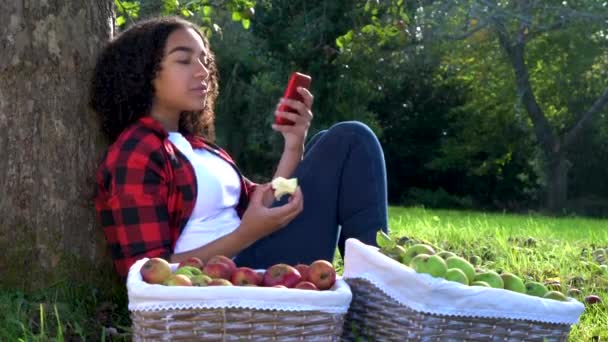 Прекрасна Афро Американська Дівчина Підліток Сидить Прихилившись Дерева Саду Їсть — стокове відео