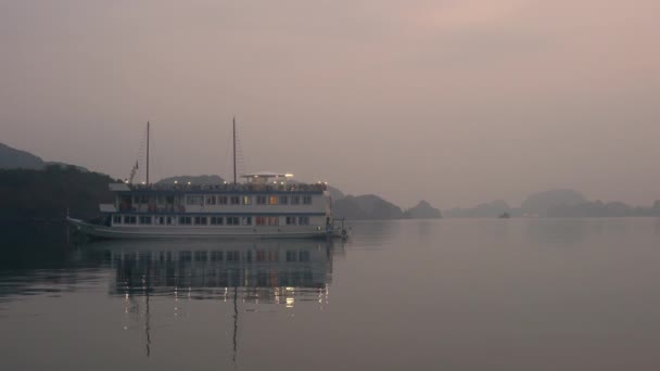 黄昏时停泊在联合国教科文组织世界遗产 下龙湾 猫巴国家公园的石灰石岛屿上的游船船 — 图库视频影像