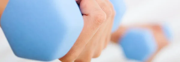 Panoramische close-up vrouwelijke handen trainen met gewichten — Stockfoto