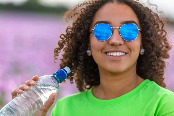 Mulher menina adolescente campo de flores vestindo óculos de sol bebendo — Fotografia de Stock