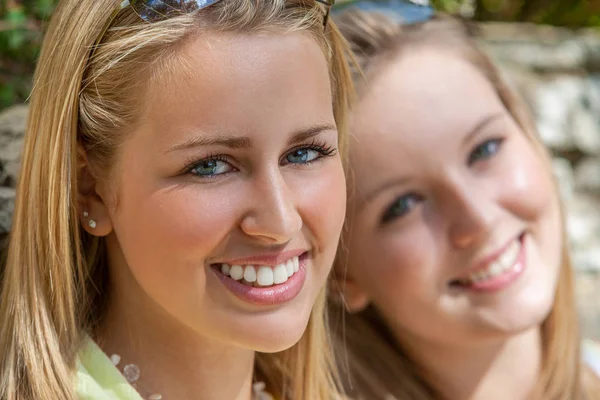 Twee tiener meisjes tiener vrouwelijke vrienden buiten glimlachend — Stockfoto