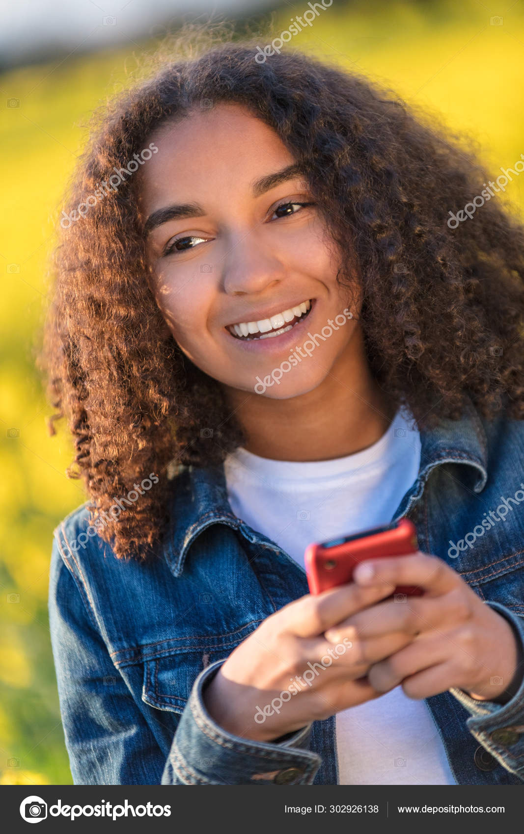 Mixed Race African American Girl Teenager On Cell Phone In Field