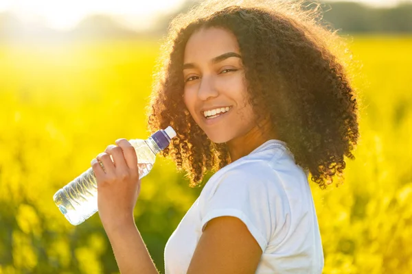 Vegyes Race African American Girl tinédzser ivóvíz a Sunset vagy a Sunrise — Stock Fotó