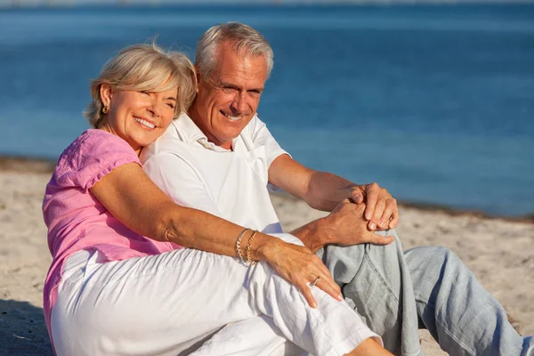 Gelukkig Senior paar zitten lachen op tropisch strand — Stockfoto