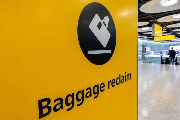 Baggage Reclaim Sign and Passenger at Heathrow Airport — Stock Photo, Image