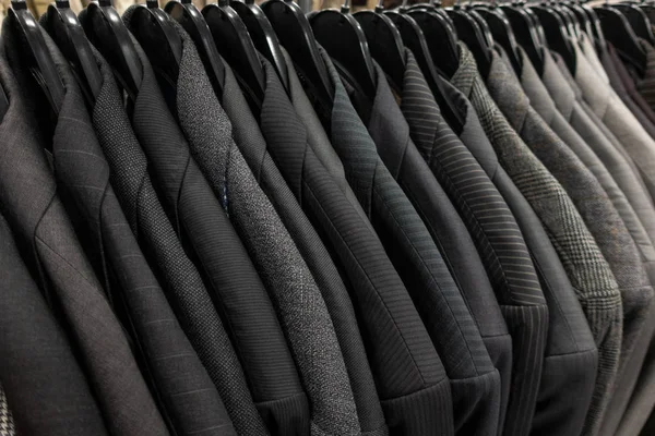 Mannelijke mannen grijze pakken op hangers op een winkel kast Closet Rail — Stockfoto