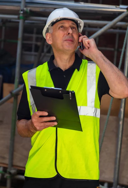 Construtor masculino preocupado arquiteto empreiteiro no local de construção usando — Fotografia de Stock