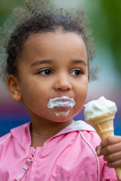 Sad Happy Biracial Mixed Race African American Girl Child Eating Ice Cream Stock Photo
