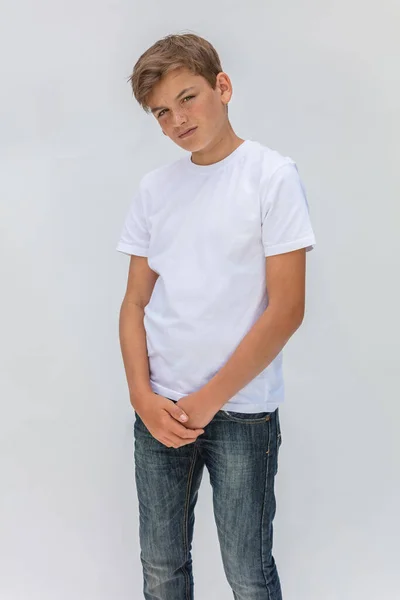 ホワイトバックグランドスタジオポートレートの男の子ティーン男性子供身に着けていますホワイトTシャツとブルージーンズ — ストック写真