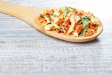 Baharatlar ve kurutulmuş sebzeler tahta bir kaşık üzerinde yatıyor. Lyophilized sebzeler.