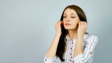 Attactive akıllı iş kadını gri arka plan üzerinde Studio kulaklık kullanarak müzik dinler.