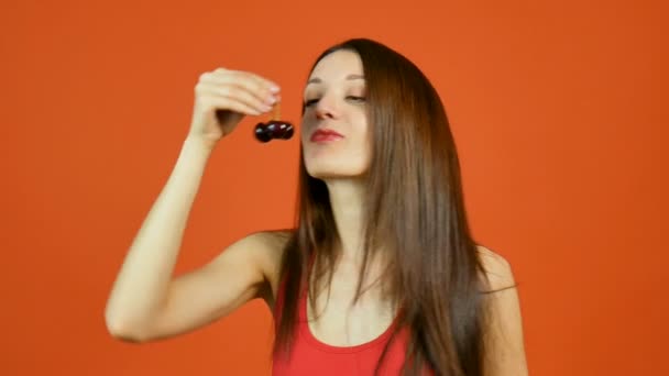 Mulher Sensual Jovem Bonita Comendo Bagas Vermelhas Escuras Fundo Laranja — Vídeo de Stock
