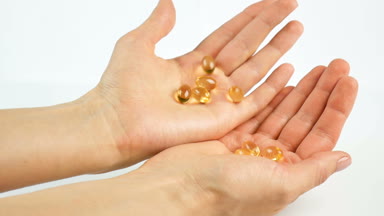 Tablet, vitaminler ellerinde. Beyaz bir arka plan üzerinde parlak sarı şeffaf vitaminler. Tıp ve sağlık, Omega 3 yağ