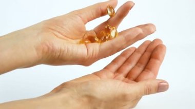 Kız onun elinde vitaminler düşünüyor. Omega 3 yağ asitleri, sağlıklı beslenme. Yakın çekim, arka plan beyaz