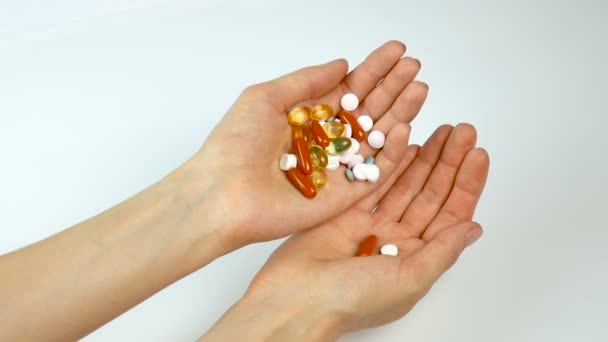 Vitamines multicolores et comprimés dans les mains de la jeune fille. Pharmacie, saine alimentation. Verser de main en main — Video