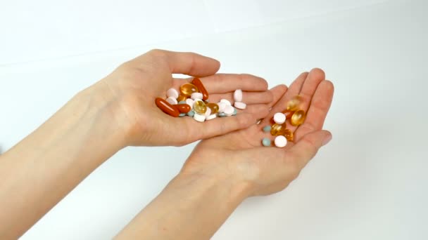 Vitaminas multicoloridas e comprimidos nas mãos da menina. Farmácia, alimentação saudável. Despeje de mão em mão — Vídeo de Stock
