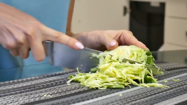 Las manos femeninas cortando la col en una tabla acostada en la mesa de la cocina. Concepto de alimentación equilibrada . — Vídeos de Stock