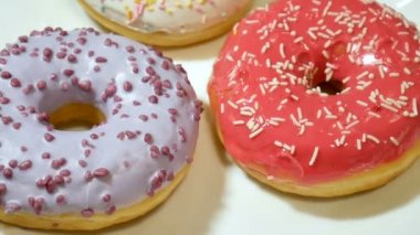 Üç donut ile beyaz plaka üzerinde renkli sprinkles. Sağlıksız şeker kötüye bağımlılık kavramı, Hd