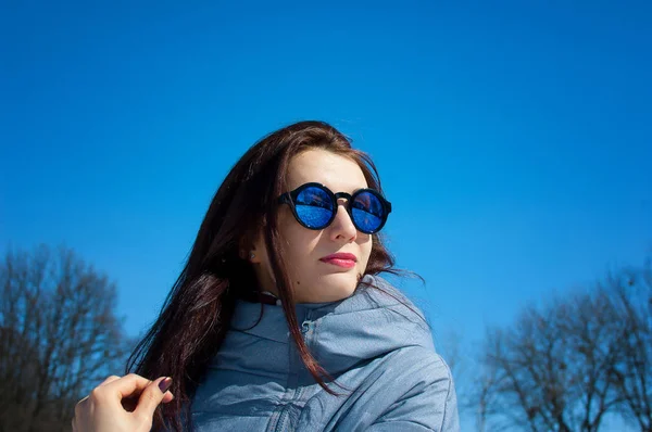 Портрет красивой молодой женщины в зеркальных солнцезащитных очках под открытым небом в раннее весеннее время . — стоковое фото
