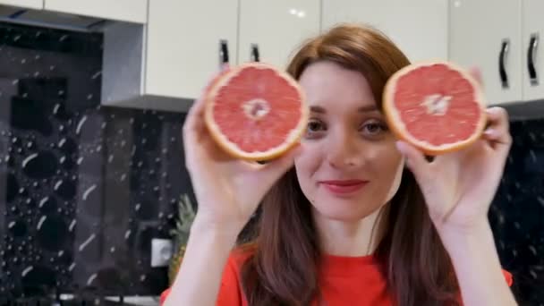 Gelukkig jonge vrouw met sappige grapefruit. Mensen op het concept van een dieet — Stockvideo