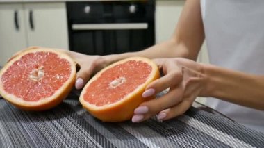 Eller genç kadın greyfurt taze bir yarısı kameraya gösterilen.