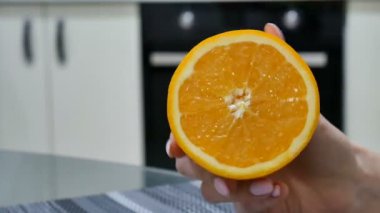 Olgun bir turuncu yarısını tutan el video yukarı kapatın. Vejetaryen kavramı