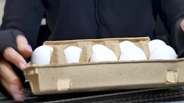 Vrouw handen met kartonnen doos van witte kippeneieren binnen. — Stockvideo