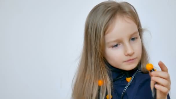 可爱的女孩与长长的金发和大蓝色的眼睛穿着一堆黄色的圣诞灯在白色的背景 — 图库视频影像