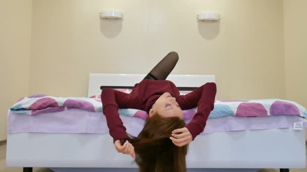 Zabawny czas w łóżku. Seksowna młoda kobieta w ciemnych bielizna i czarne pończochy, śmiejąc się i patrząc na kamery. — Wideo stockowe