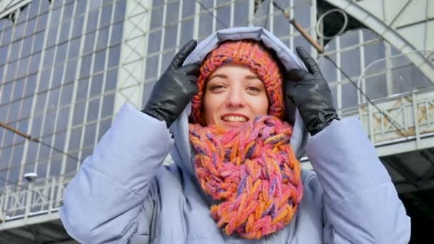 Outdoors female portrait of cute adult girl wearing bright colorful hat with scarf and looking at the camera — Stock Video