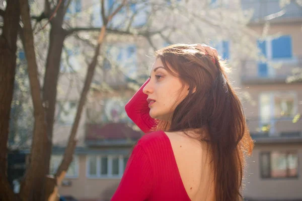 Mulher bonita com lábios sensuais em camisa vermelha desfrutando de primavera na cidade . — Fotografia de Stock