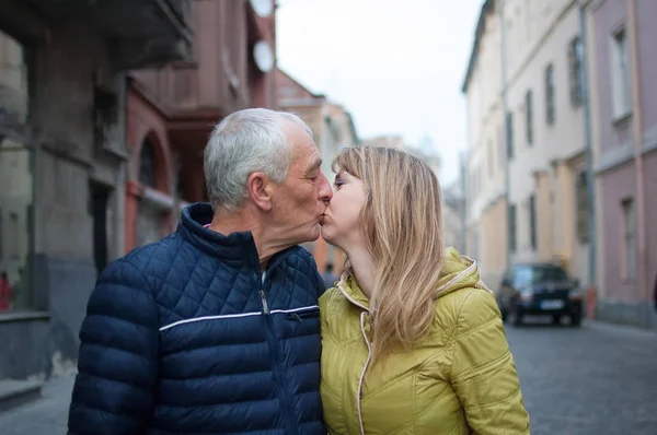 Pareja romántica feliz con diferencia de edad besándose al aire libre en la ciudad antigua durante principios de primavera u otoño . —  Fotos de Stock