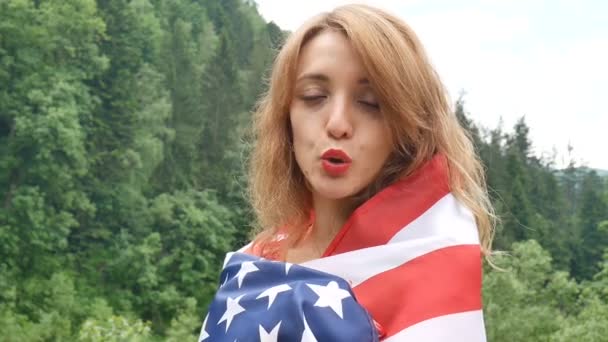 Портрет прекрасної дівчини в червоному платті на тлі лісових гір і неба. День незалежності США, патріотичний день — стокове відео