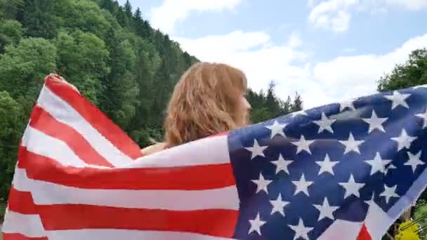 Porträtt av en vacker flicka i en röd klänning mot bakgrund av skogs bergen och himlen. USA självständighetsdagen, patriotiska dag — Stockvideo