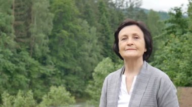 Dağlarda olgun emekli kadının yakın portresi, seyahat konsepti, anneler günü, sosyal kavram