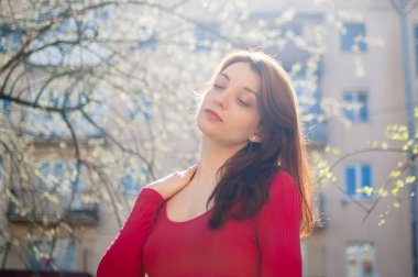 Güneş parlarken güneşli bahar gününde açık havada yürüyen şık çekici esmer kadın Outdoors portre