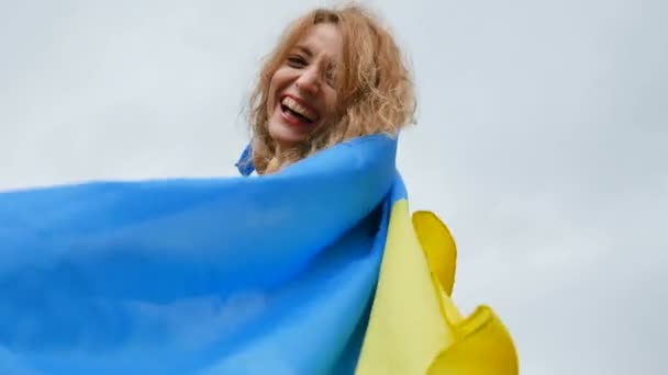 Retrato de jovem patriótica segurando azul e amarelo bandeira ucraniana sobre o fundo do céu, enquanto celebra regime de isenção de visto — Vídeo de Stock