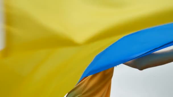 Riendo joven feliz con bandera ucraniana azul y amarilla en sus manos sobre el fondo del cielo — Vídeos de Stock